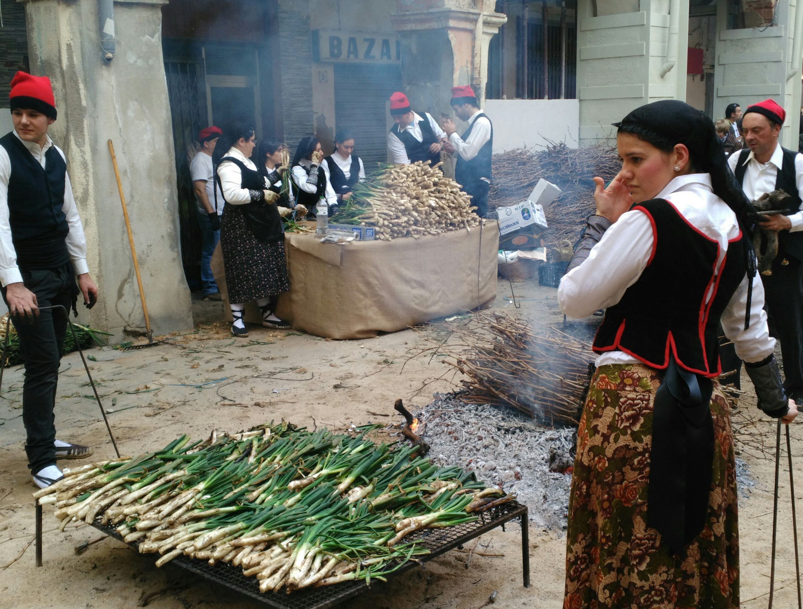 calçots a la brasa con salsa romesco, uno de los platos más tradicionales de Valls