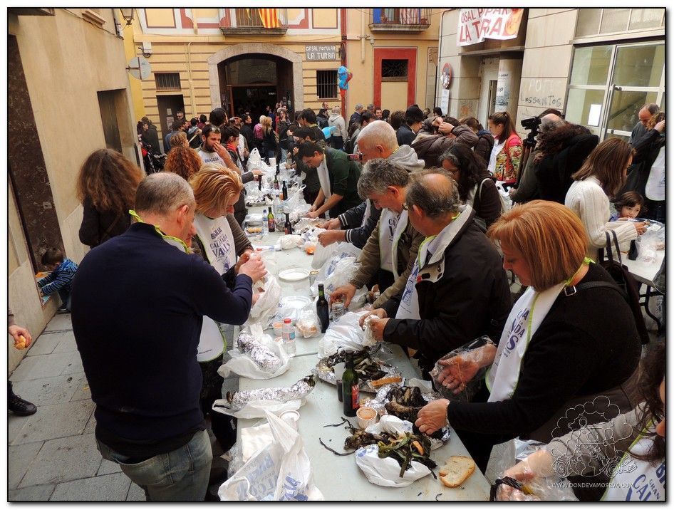 Comensales disfrutando de la calçotada en Valls con babero típico
