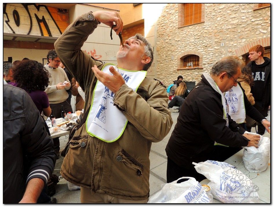 Concursante levantando calçots hacia la boca en la competición popular de Valls.