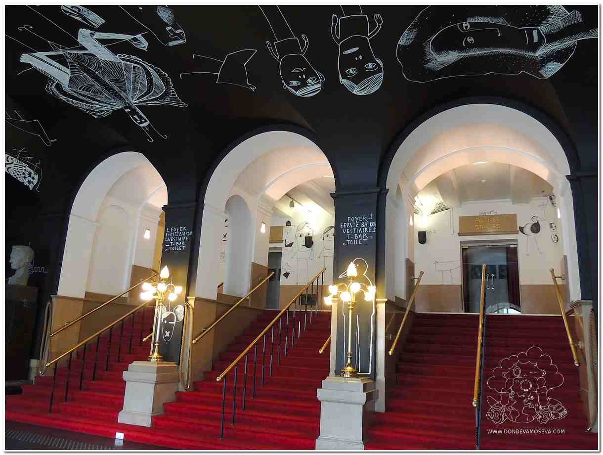 Foyer del Teatro de Gante con iluminación cálida y decoración elegante
