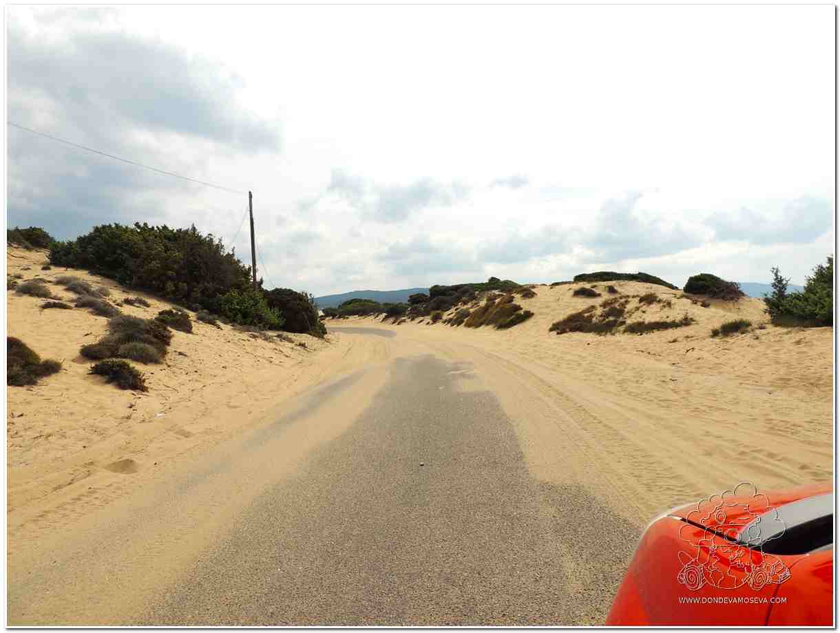 Camino de arena que conduce a la playa Piscinas en la Costa Verde de Cerdeña, rodeado de dunas y vegetación salvaje.