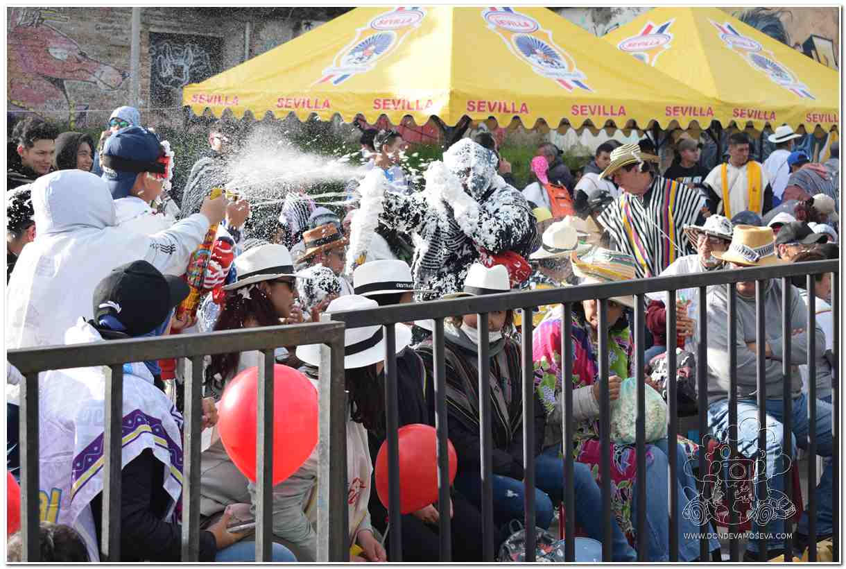 Público disfrutando de una batalla de carioca con espuma blanca en el Carnaval de Negros y Blancos.