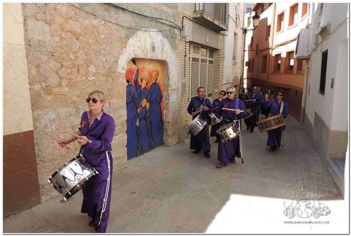 Cofradías con túnicas moradas desfilando por las calles de Calanda en Semana Santa
