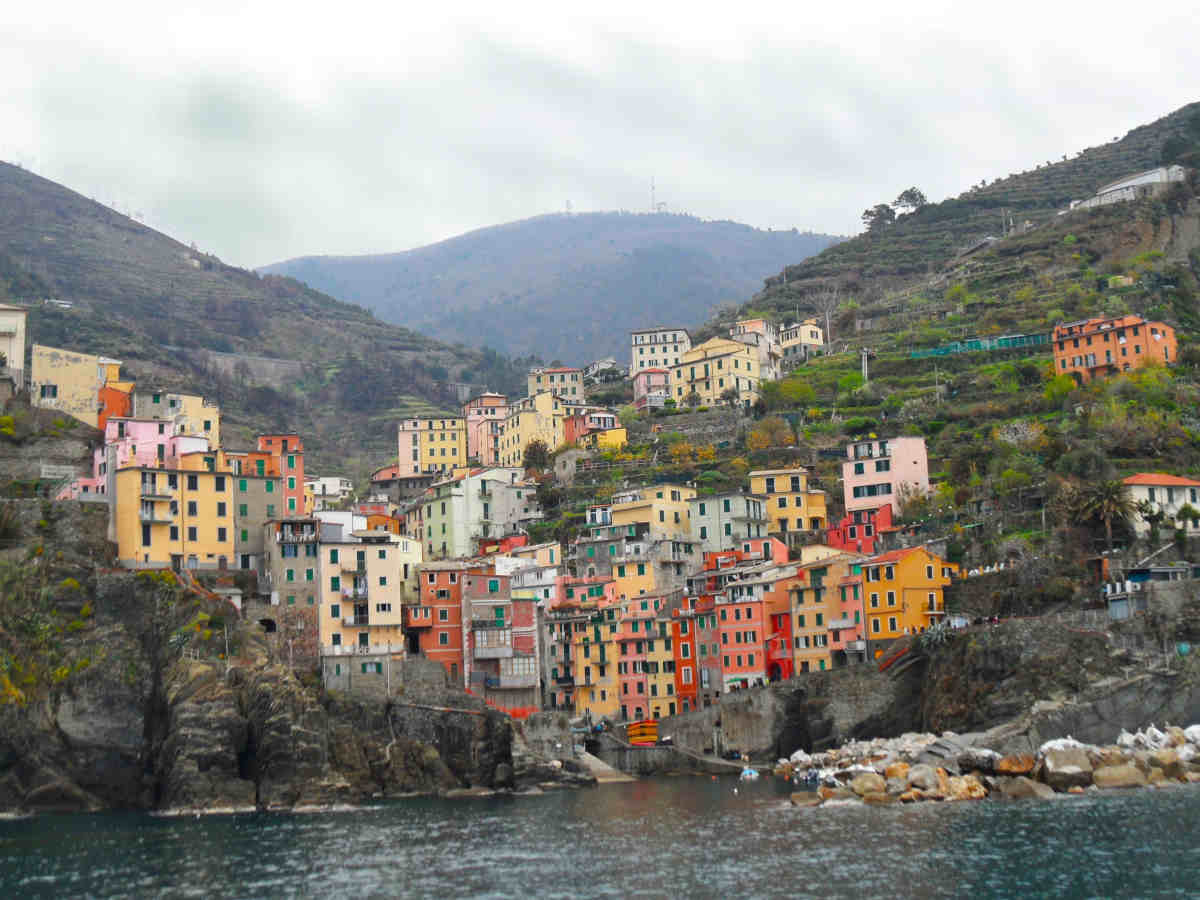 Riomaggiore desde el mar con sus casas de colores en vertical en Cinque Terre