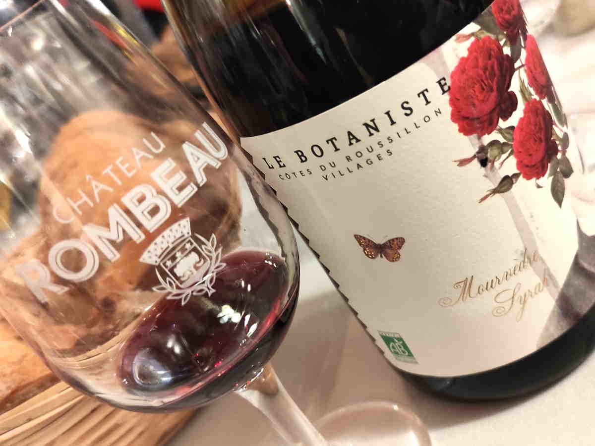 Copa de vino de Rivesaltes junto a botella de Château Rombeau en el Rosellón