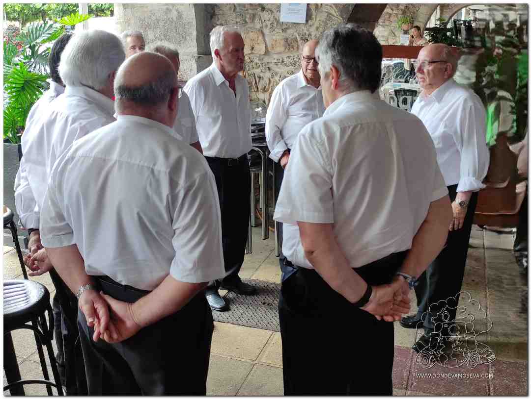 Grupo cantando bajo los soportales de San Vicente de la Barquera