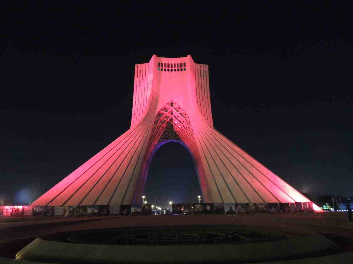 Nocturismo en Teherán frente a la Torre Azadi iluminada de noche