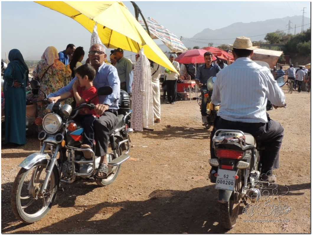 caminando entre personas y motos en un mercado tradicional del Atlas marroquí