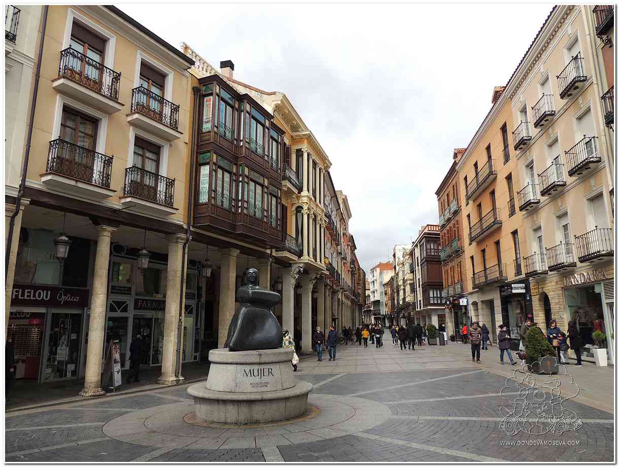 Calle Mayor de Palencia con soportales y la escultura Mujer